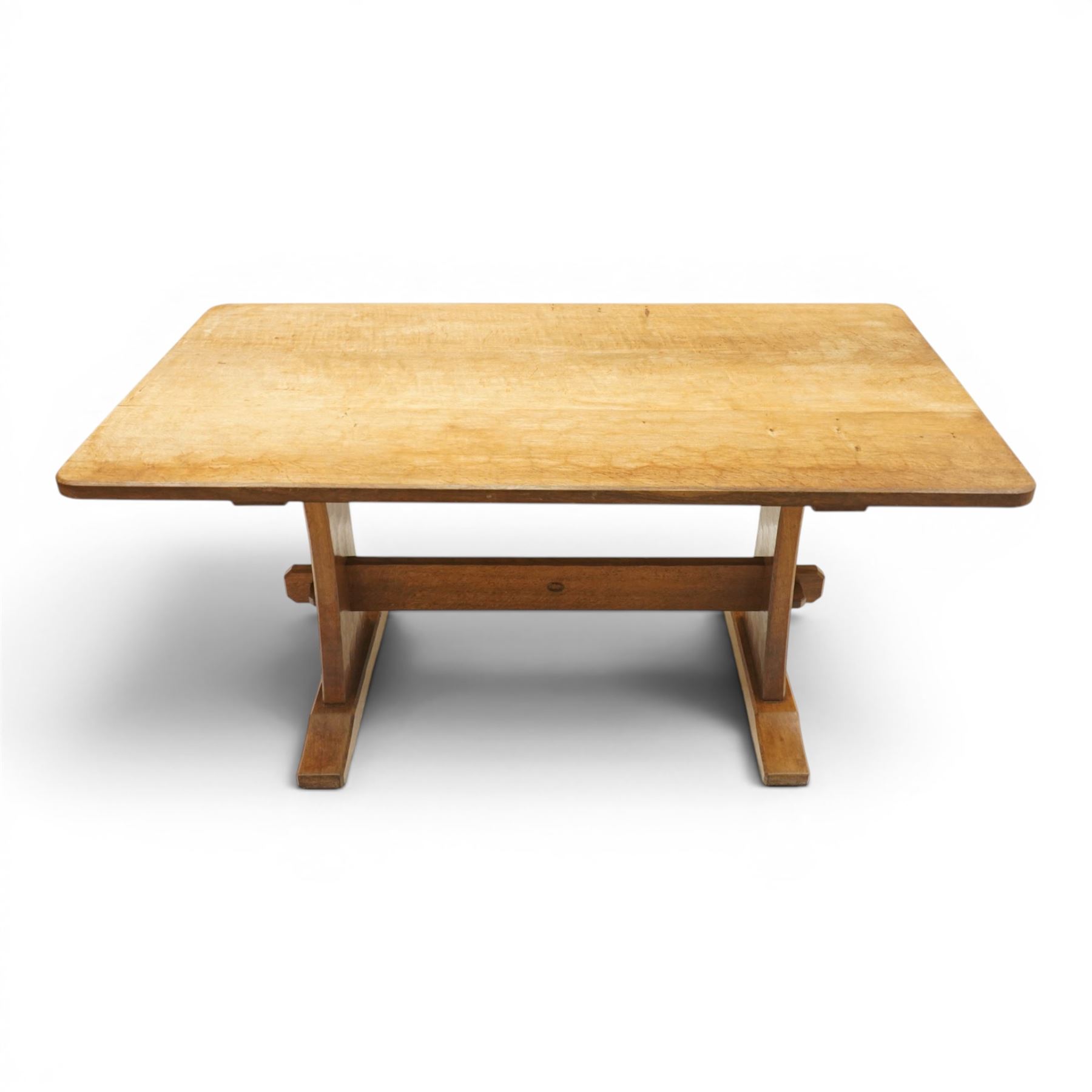 Acornman - 5' adzed oak dining table, rectangular top above a trestle base united by a stretcher with carved acorn signature, by the workshop of Alan Grainger of Brandsby
