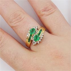 14ct gold emerald and diamond crossover ring, two oval cut emeralds with round brilliant cut diamond surround, with channel set calibre cut emerald shoulders, stamped 585