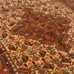 North West Persian Malayer hand-knotted rug, ivory field with central stepped lozenge medallion with angular pendants, surrounded by rows of stylized boteh and geometric floral devices within multiple geometric and stylized vine borders, with fringe ends