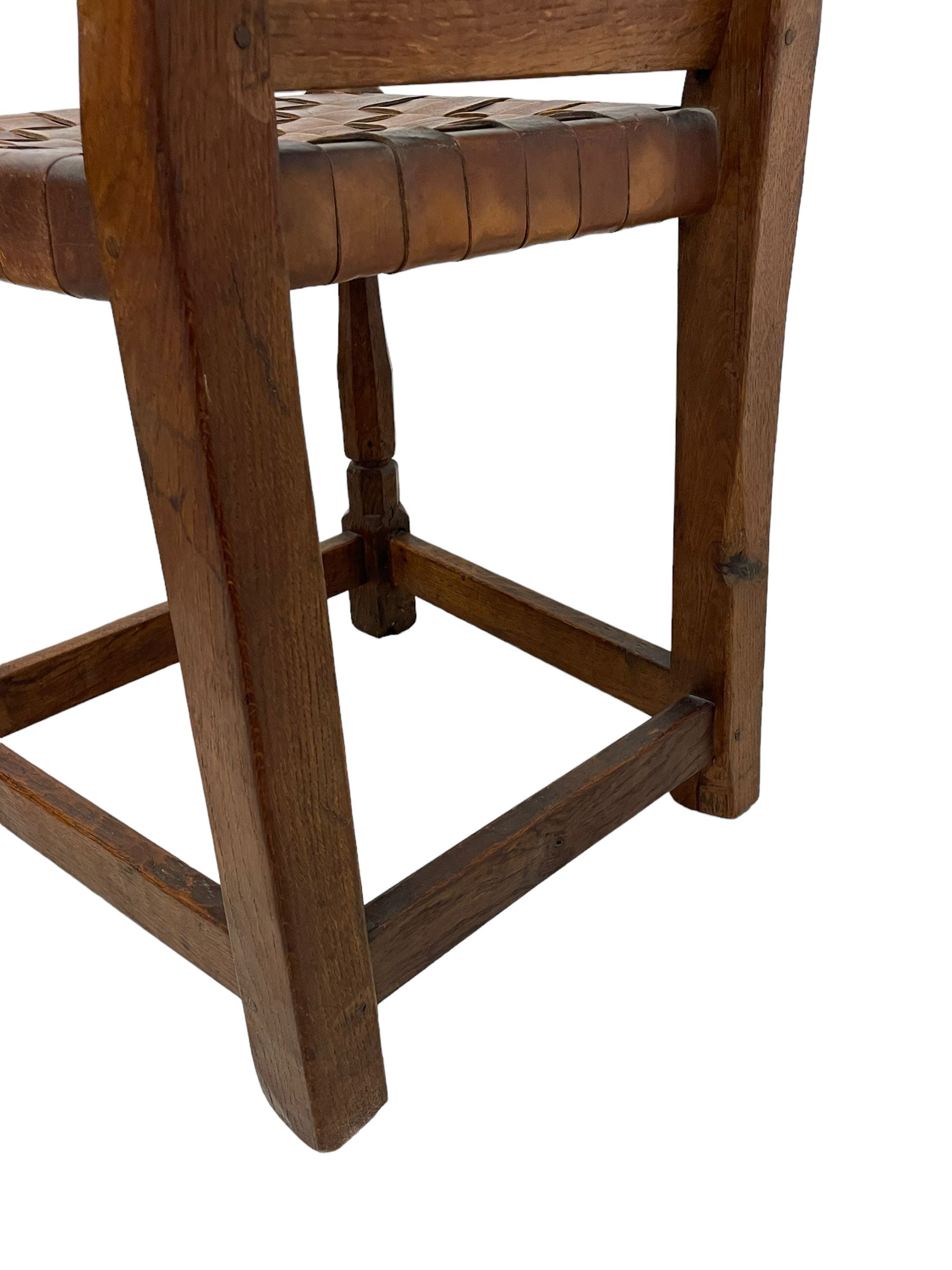 Mouseman - circa. 1930s set of six (4+2) oak dining chairs, panelled back carved with the Bagshawe family crest, the moto 'Forma Flos Fama Flatus' over an arm grasping a bugle-horn with ribbon tie and Yorkshire rose motif, adzed frame, leather lattice strap seat, on octagonal supports united by stretchers, two carvers and four side chairs, each carved with mouse signature, by Robert Thompson of Kilburn 

Provenance: Owned since manufacture by the Bagshawe family, descendants of the Staithes Group Artist Joseph Richard Bagshawe RBA (1870-1909).