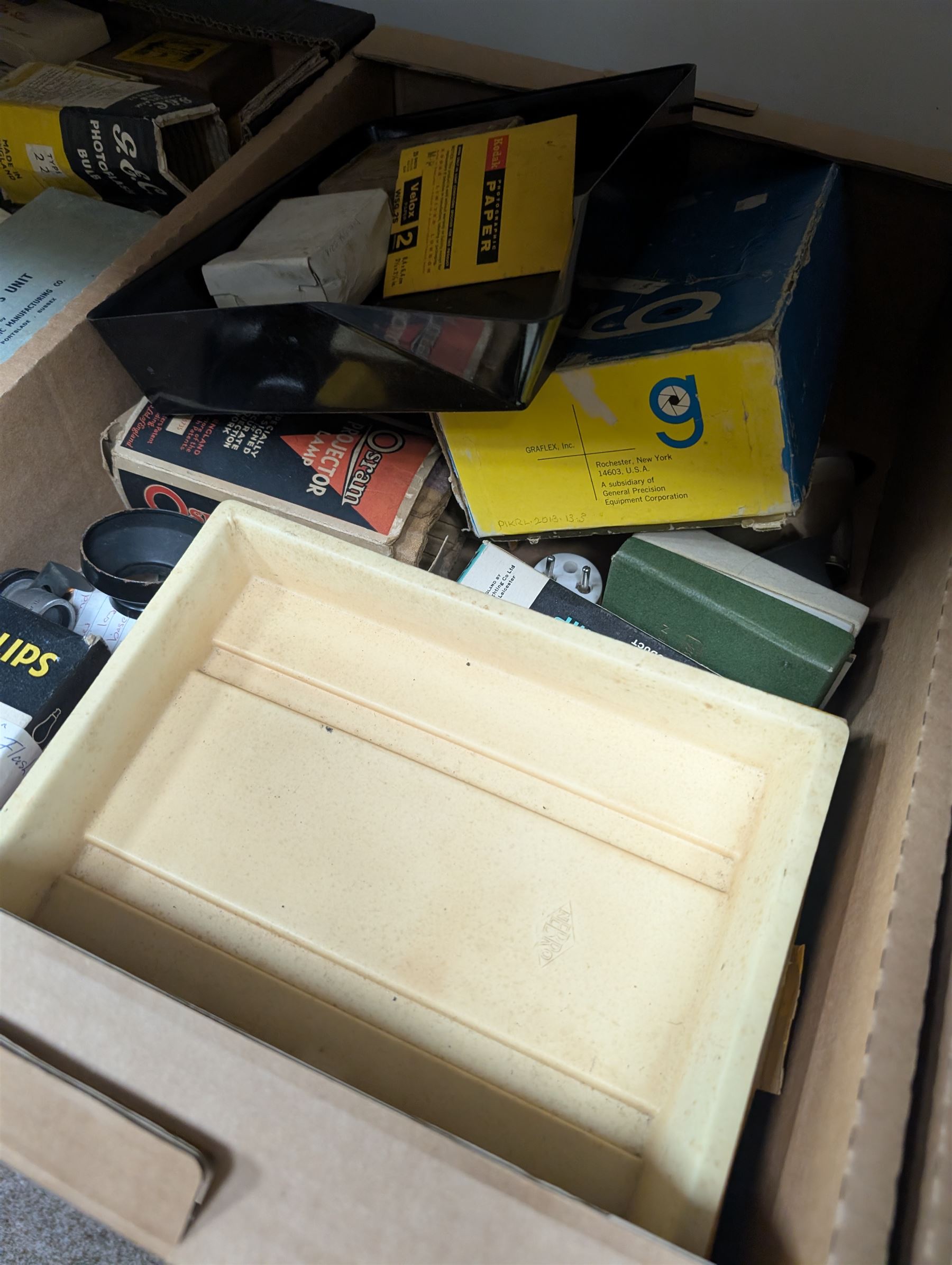 Collection of photography and photograph development accessories, including bulbs, development tanks, trays, projector lenses, etc