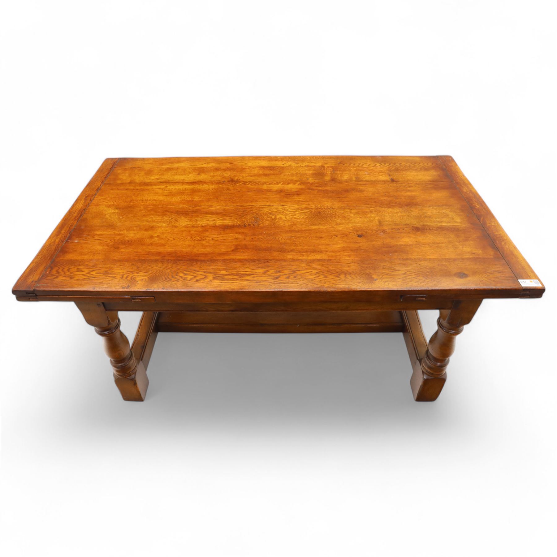 20th-century good quality solid oak extending refectory table, planked, constructed rectangular top with two extending leaves on the underside above a plain frieze raised on four turned baluster supports united by stretchers on block feet, 260cm extended
