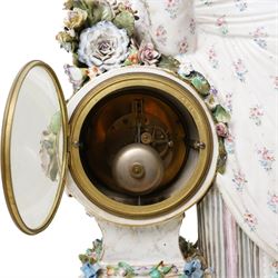 Large19th century  German porcelain mantel clock with white dial and striking movement, the case with a standing figure of Flora resting on a pillar with floral applied decoration, the base painted eith landscape and floral panels on paw feet H77cm W43cm