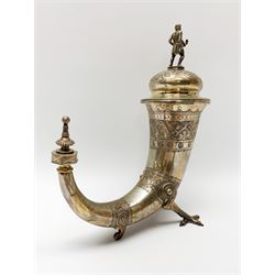 Late 19th century Danish silver drinking horn and cover, the body with hexagonal and beaded finial, raised upon two talon feet and further scroll foot, chased with scrolling foliate and zoomorphic bands, the detachable domed cover with conforming decoration surmounted by a figure holding a hammer, the cover interior impressed with maker's mark (partly worn and indistinct), alongside Danish Three Towers mark for 1881, with the Assay Master mark for Simon Groth (1863-1904), H23.5cm, weight 14.75 ozt (459 grams)

