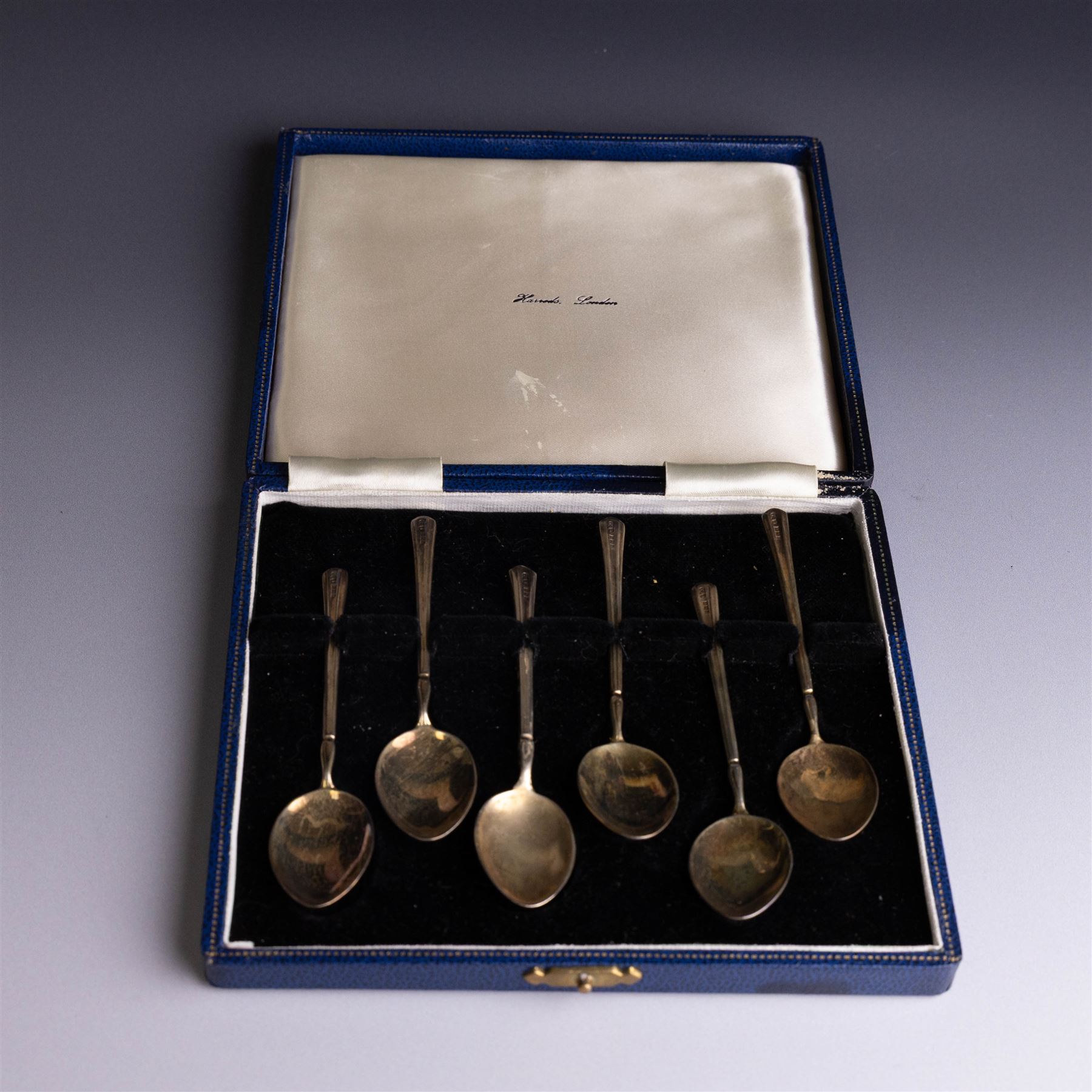 Set of six mid 20th century silver-gilt and guilloche enamel coffee spoons, the undersides of the bowls painted with colourful floral decoration, hallmarked Turner & Simpson Ltd, Birmingham 1960, within Harrods case