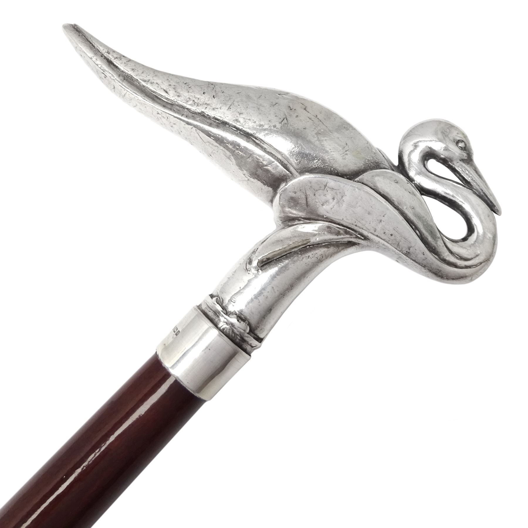 Art Deco style Italian 'Rivestito' covered silver walking stick handle, modelled in the form of a swan, stamped 'R', upon a silver collar hallmarked Birmingham 1986, makers mark DH-L, and hardwood shaft, L96cm

Provenance by vendor repute: 
This walking cane comes from a private collection amassed by the current vendors mother who was an Antique dealer specialising in walking sticks, working at the Portobello Road Antique Market in London for over forty years. 
In 1988 the prop crew from LWT (now ITV) visited Portobello Road looking for, amongst other items, a signature stick for David Suchet to use in his portrayal of Agatha Christie's Poirot. 
At the time this particular walking stick was one of five in possession. The prop crew chose and purchased another of the five which was then used by Suchet throughout all seventy episodes of the much loved series. 
Following the conclusion of the series Suchet was gifted his particular cane, which has been loaned to and can now be seen at the Agatha Christie Gallery at the Torquay Museum. 
