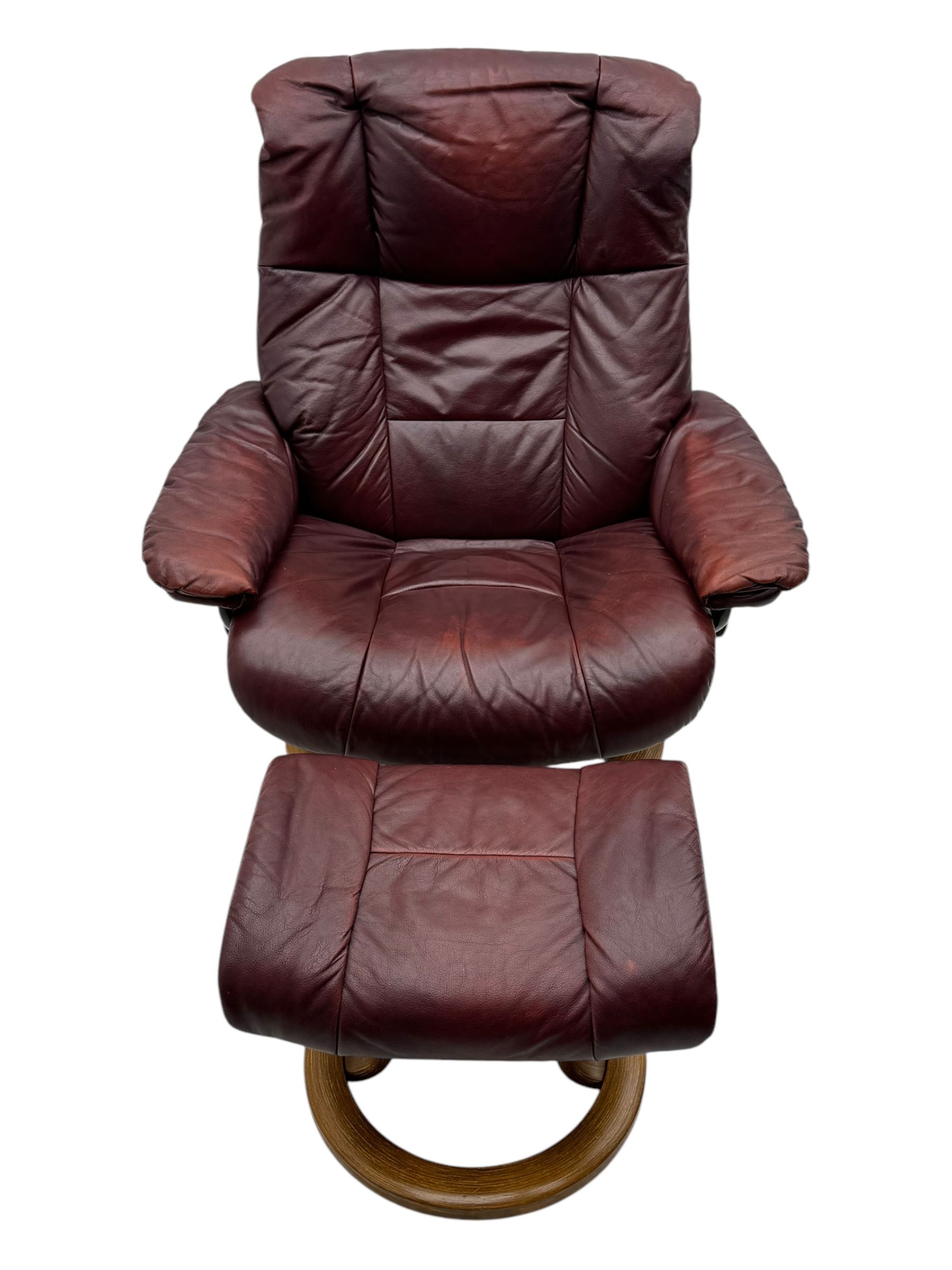 Ekornes Stressless, swivel armchair upholstered in red leather, with matching footstool supported on Oak bases