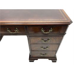 Large Georgian design mahogany twin pedestal partner's desk, moulded rectangular top with canted corners and inset leather writing surface, fitted with nine drawers and two cupboards, the pedestals with canted uprights decorated with blind fretwork, on ogee bracket feet
