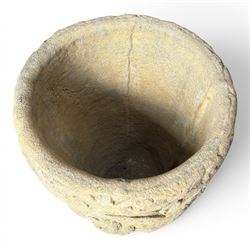 Cast stone Romanesque design urn of tapering form, decorated in relief with motifs of zoomorphic figures and swans within foliate and guilloche cast architectural arches with Neoclassical columns, in weathered finish