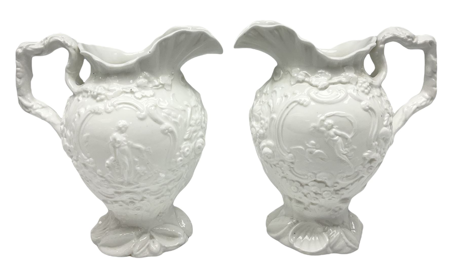 Pair of early/mid 19th century Copeland and Garrett white glazed pitchers, modelled in the Georgian style and moulded with the figures of Venus the Roman Goddess of Love, and Aurora the Roman Goddess of Dawn, within C scroll borders and foliate surround, the naturalistically modelled handle leading to a fruiting vine beneath the rim, upon a spreading base moulded with seashells, with printed green crowned wreath mark beneath, H20cm
