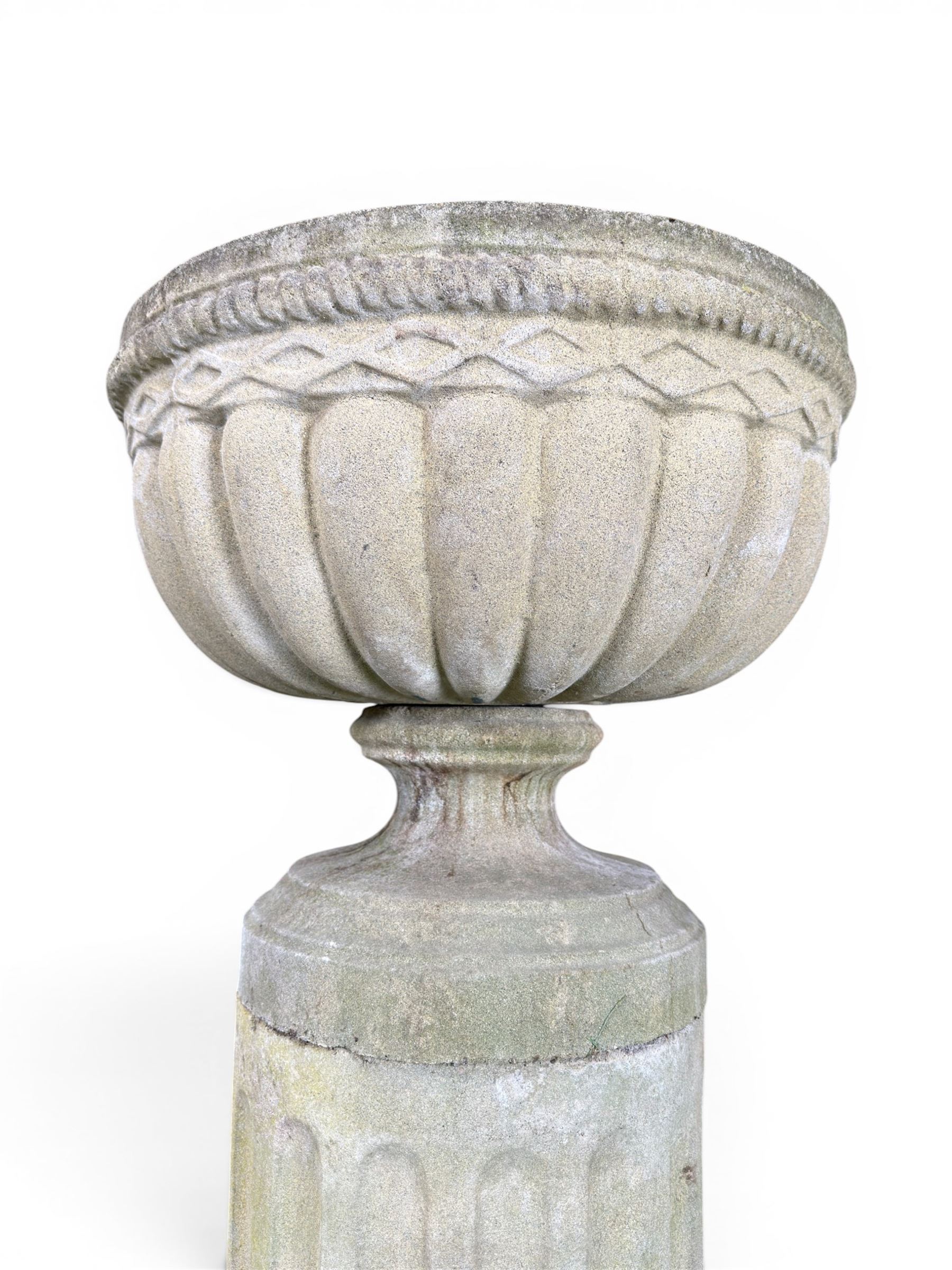 Four 20th century good quality weathered cast stone pedestal urns, circular lobed bowls with rope twist and lattice border, raised on squat base with fluted columns