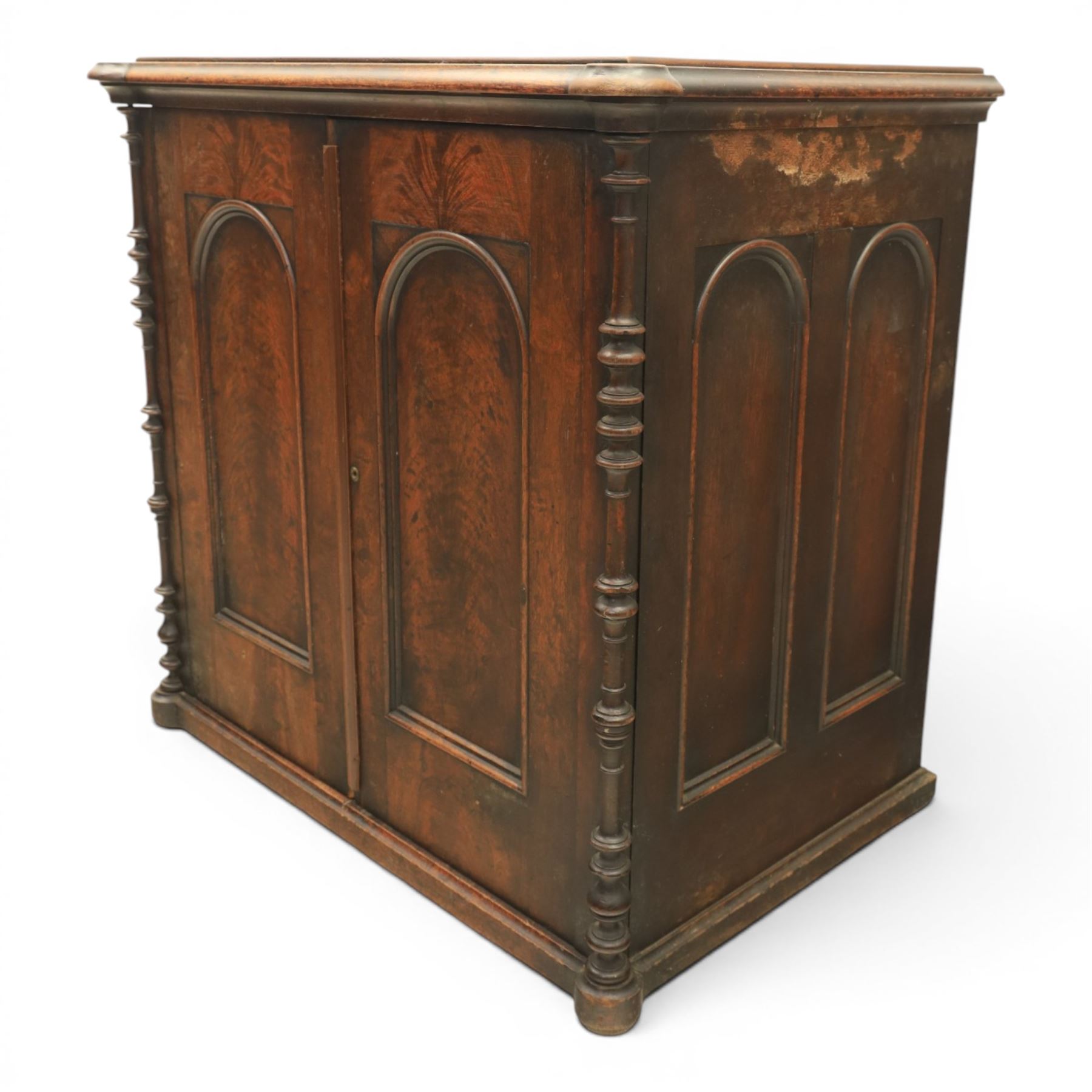 Victorian mahogany low cabinet, shaped rectangular top fitted with two arch panelled doors flanked by turned pilasters, enclosing two shelves and fitted with four short drawers with turned knobs 