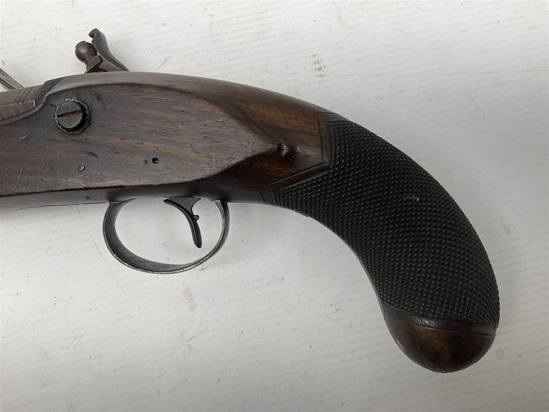 Early 19th century 16-bore flintlock single barrel travelling pistol, the 21.5cm stub twist octagonal barrel with two barrel pins and ramrod under, engraved lock plate with roller frizzen, engraved trigger guard with pineapple finial, walnut stoock with chequered grip L40cm overall
