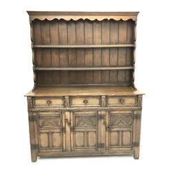 Jacobean style oak dresser, raised two tier plate rack with projecting cornice above three drawers above three cupboards, stile supports