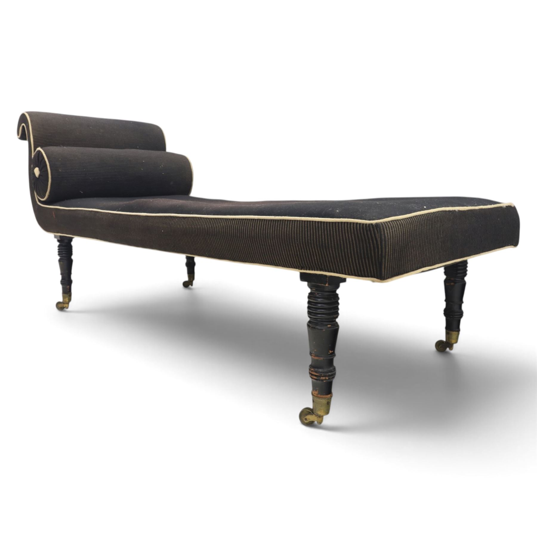 Victorian ebonised chaise longue, upholstered in black fabric with scroll headrest and bolster cushion, rectangular seat with rounded corners, raised on turned supports terminating in brass and ceramic castors