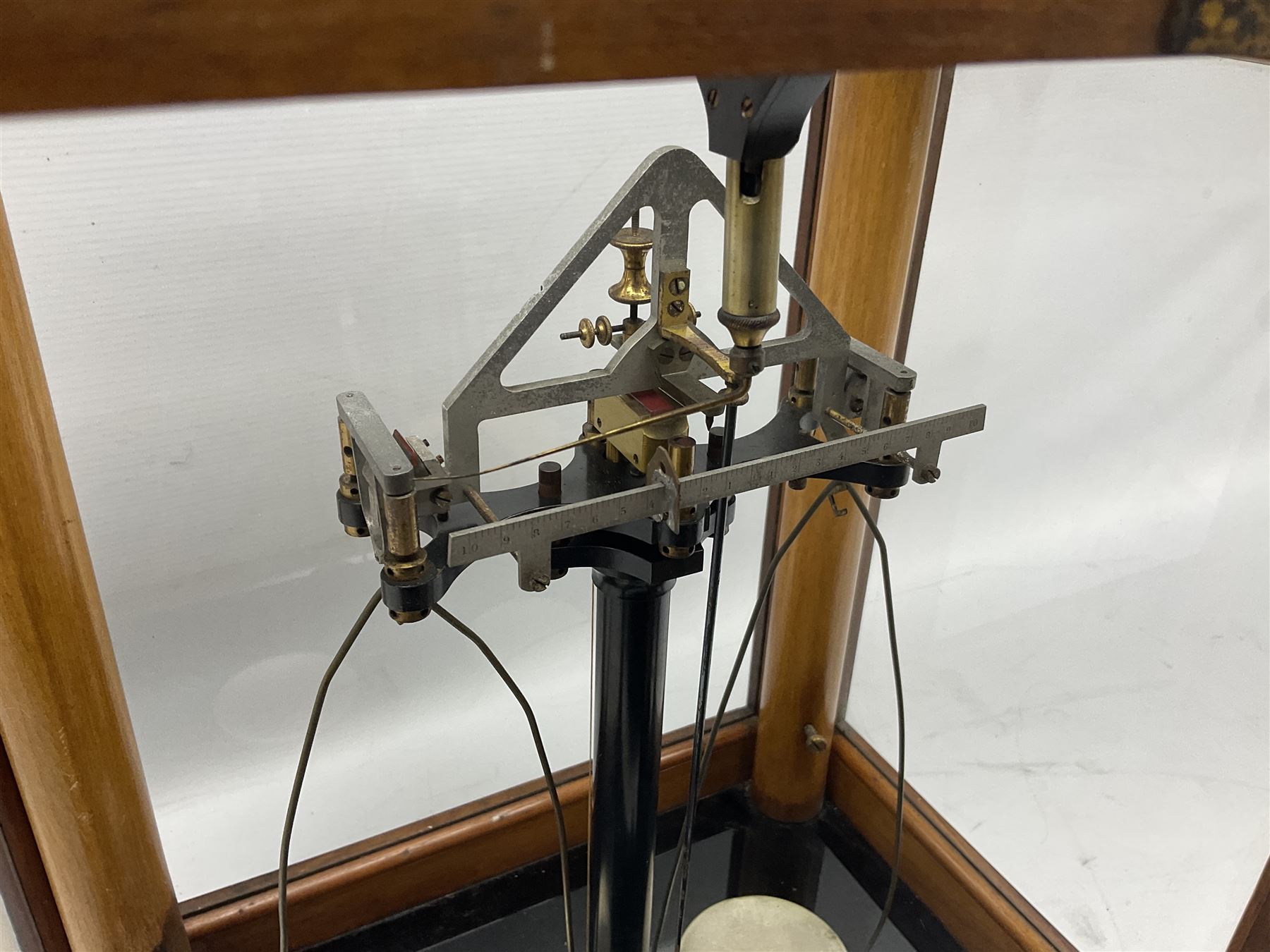 Set of laboratory balance scales by Reynolds & Branson of Leeds in fully glazed mahogany case with rise-and-fall front door, black vitrolite base with brass feet and hand cranked action L40cm H51.5cm D30cm; and bakelite cased set of brass weights