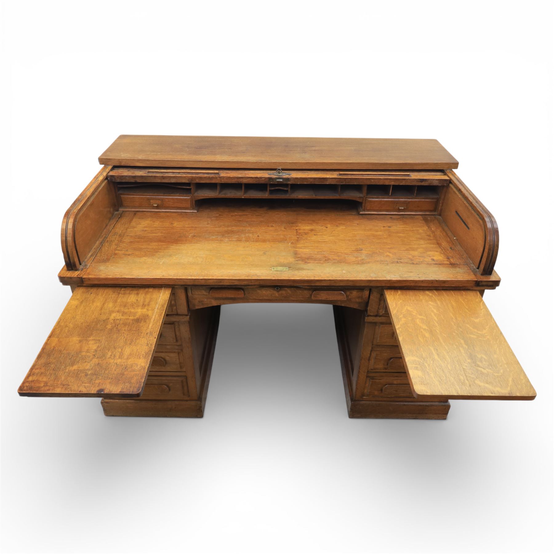 Globe Wernicke - Oak roll top desk, fitted with nine drawers, oak tambour roll top revealing a fitted interior, with single frieze drawer, flanked by four drawers to each pedestal, on a plinth base