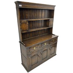 Georgian design oak dresser, the two-tier plate rack with two flanking spice cupboards, the base fitted with three drawers over three arched fielded panelled cupboards, lower moulded edge on block feet