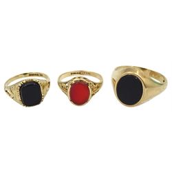 Two gold black onyx signet rings and an oval carnelian signet ring, all hallmarked 9ct