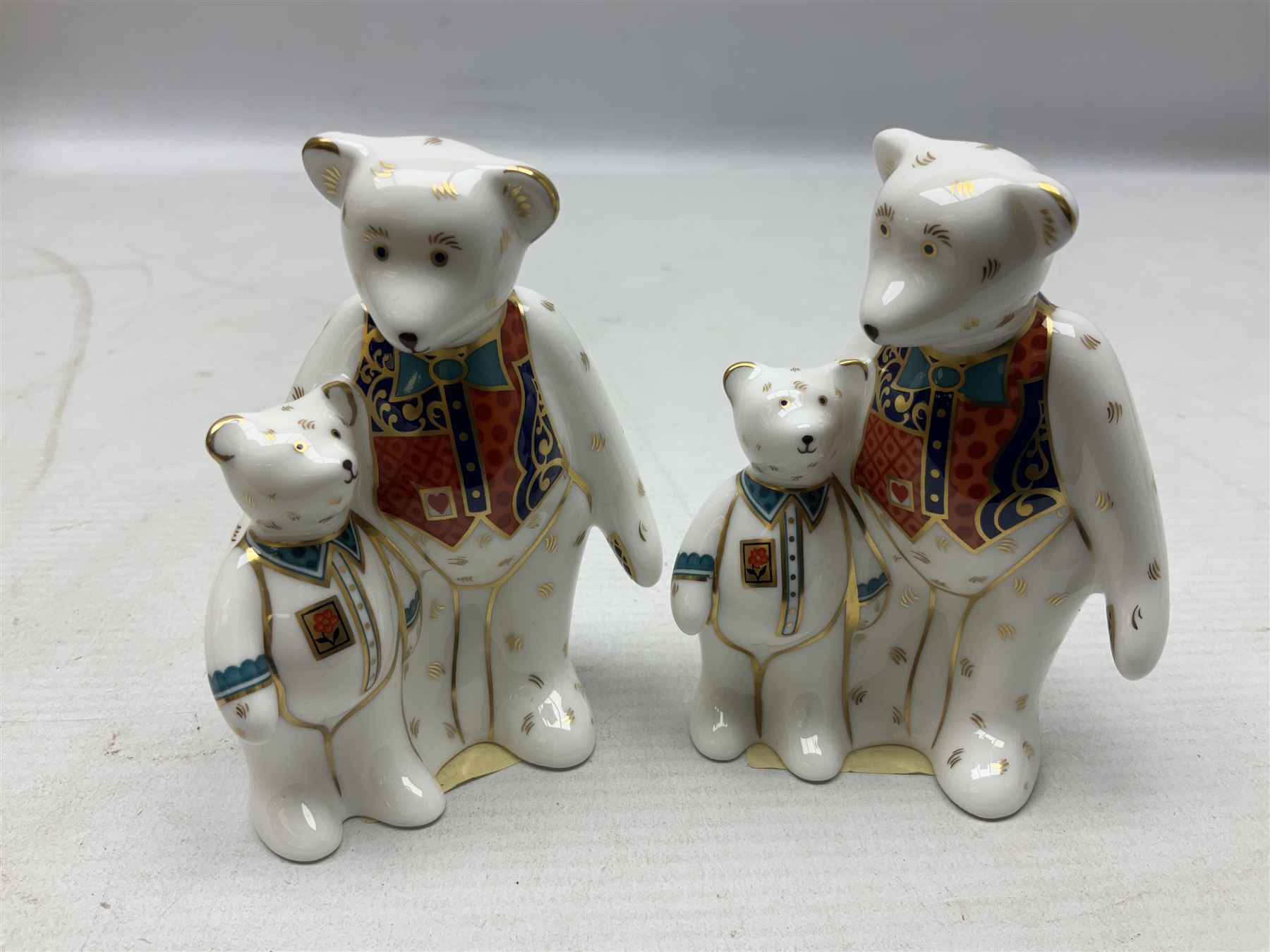 Four Royal Crown Derby teddy paperweights, comprising Teddy Cook, two Teddy George and Seated Teddy, all without stoppers, together with Crown Namestake with gold stopper 