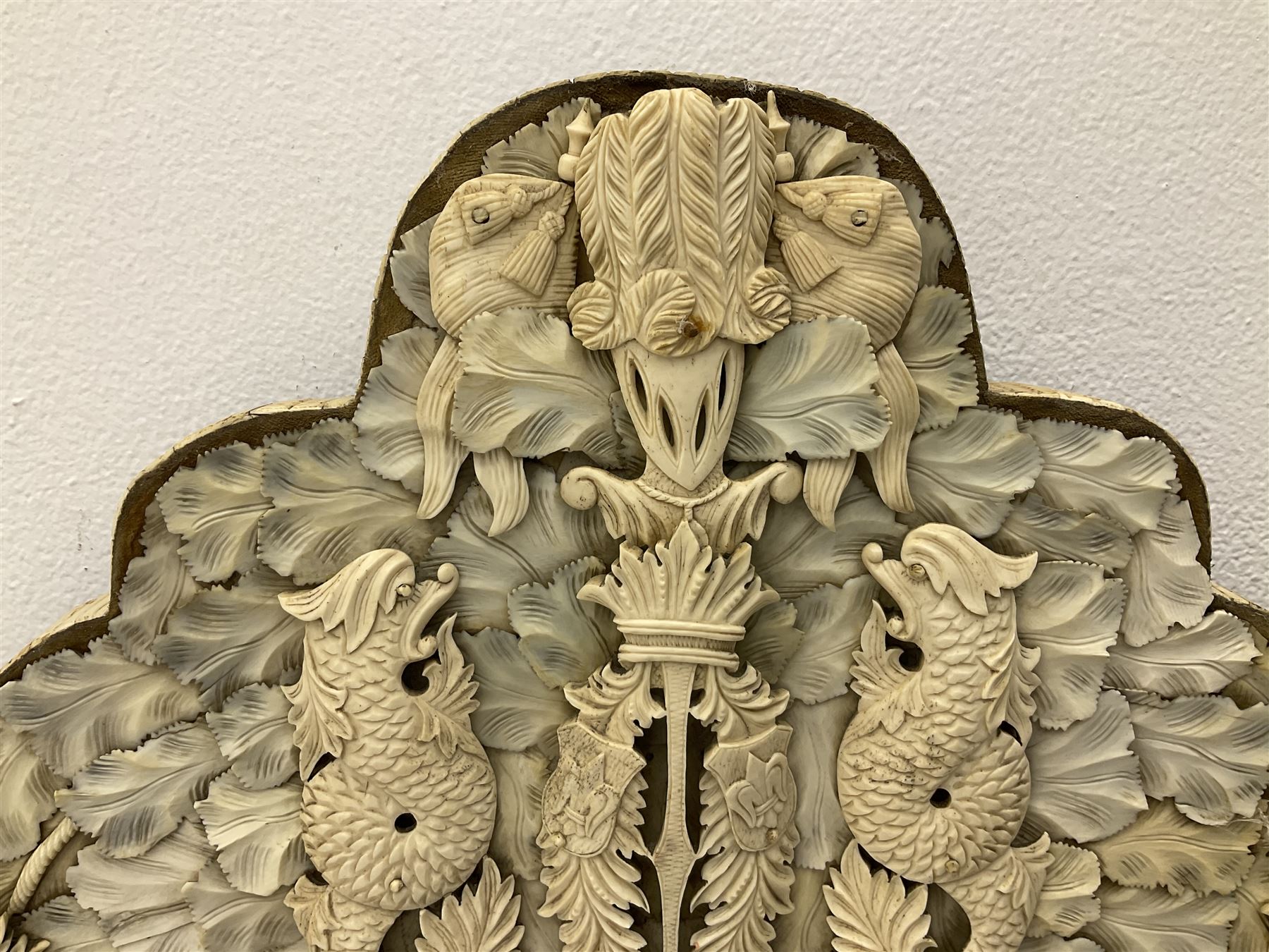 Pair 19th century French Dieppe bone and ivory wall mirrors, the oval bevelled mirror plates within rectangular frames with shaped tops, profusely decorated with ivory leaves, further detailed with carved bone armorial type crest inscribed 'SGOTORVM', putti, fish and mask heads, H81cm W48cm