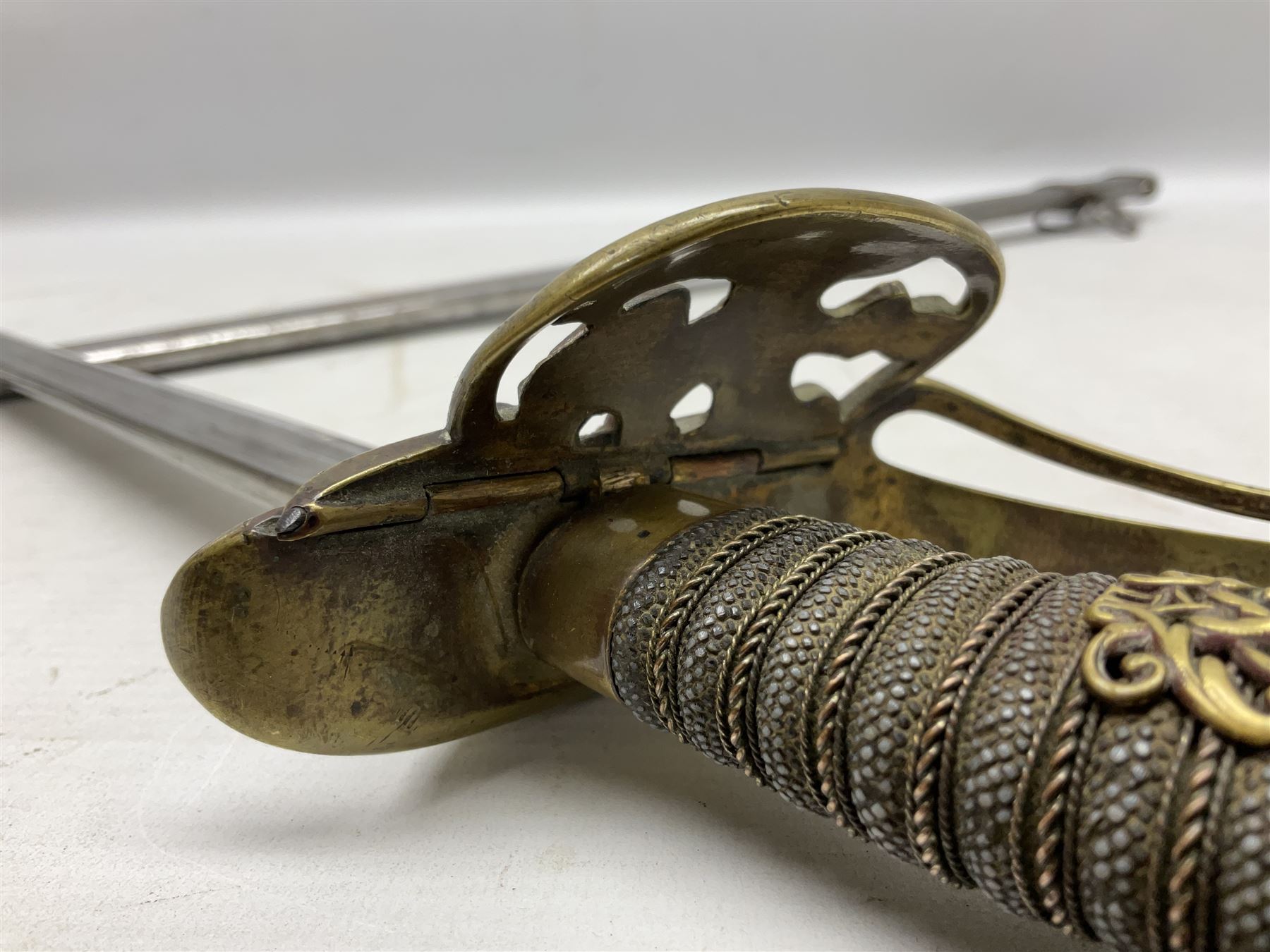 19th Century Prussian Infantry Officers 1889 pattern sword, the 77.5cm double fullered blade with makers mark to the ricasso for Weyersberg Kirschbaum & Co; curved brass top pommel with brass wire bound fish skin grip applied with crowned  Wilhelm II monogram; folding cross guard with Imperial eagle and double bar knucklebow; in polished steel scabbard with single suspension ring L94.5cm overall