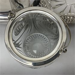 Edwardian silver plated swing handled basket, with pierced sides, engraved May 18 1904, with engraved initial A to handle, upon four ball and claw feet, together with other silver plated item including a similar swing handled basket, with embossed floral border, upon a rectangular pedestal, an egg coddler, with lion mask handles, hot water pot and a moulded glass biscuit barrel, coddler H22cm