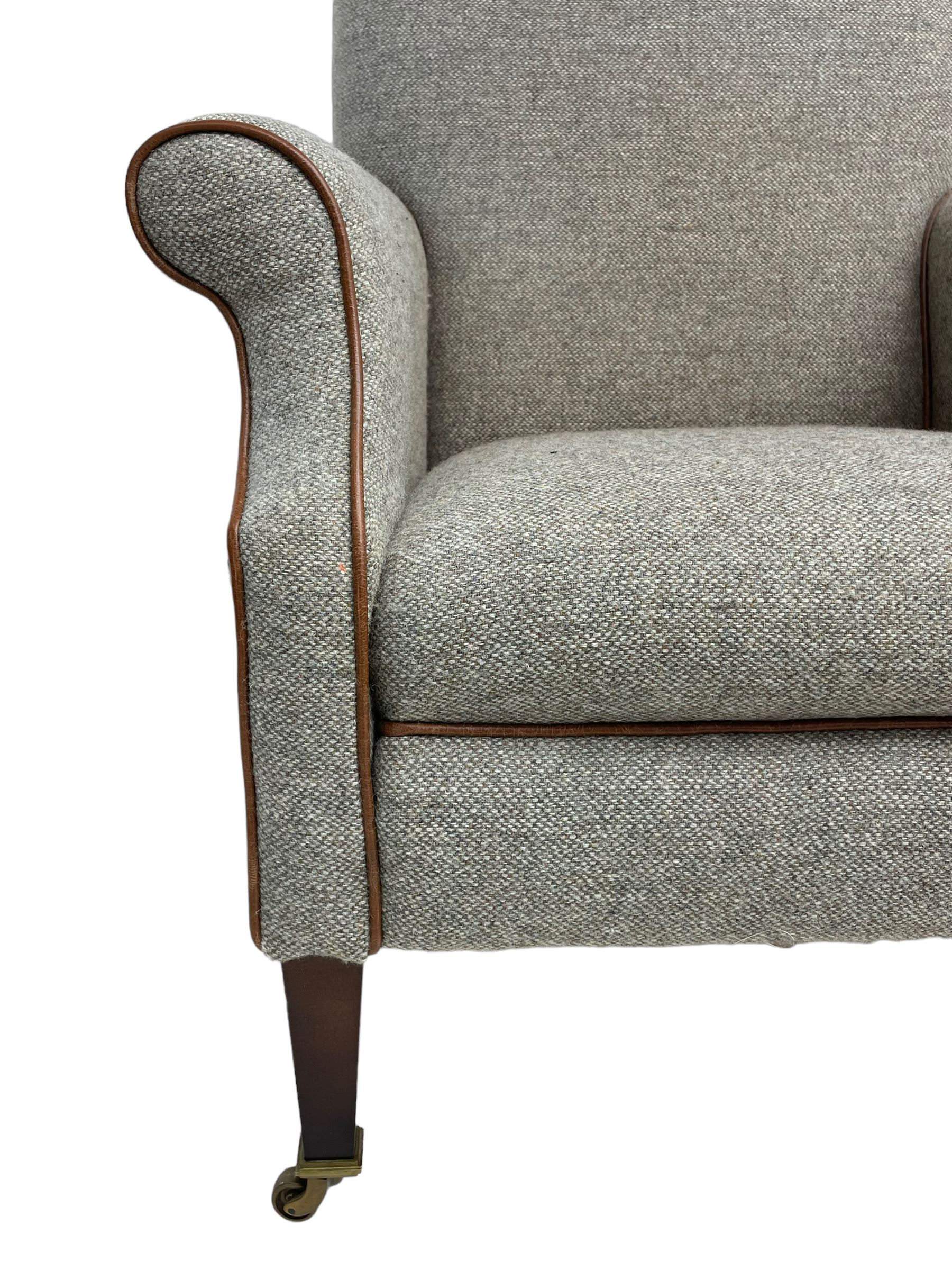 Interiors at Nine to Eleven - Edwardian design armchair, traditional shape with rolled arms, upholstered in 'Harris Tweed' fabric with leather piping, raised on square taping supports with castors