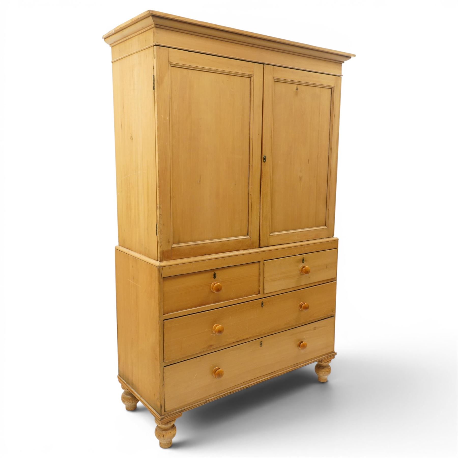 Victorian stripped pine housekeepers cupboard, projecting cornice over two panelled cupboard doors enclosing two shelves, the base fitted with two short over two long graduating drawers, lower moulded edge over turned feet