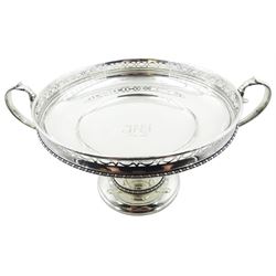 Early 20th century silver twin handled pedestal bowl, the bowl of circular form with engraved initials and date to interior, pierced rim above a bead and dart border, and twin scroll handles, upon a knopped stem and spreading circular base with conforming bead and dart band, hallmarked Sibray, Hall & Co Ltd, London 1917, including handles H16.5cm rim D22.5cm, approximate weight 30.18 ozt (939 grams)