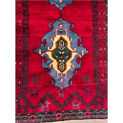Northwestern Persian Cirjan hand-knotted carpet, madder red field with three linked stepped lozenge medallions in blue, ivory and green, flanked by angular motifs within a dark green border of serrated leaves and rosettes 