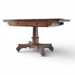 Victorian rosewood library table, rounded rectangular top with two frieze drawers with turned wooden knobs, quatriform base with scrolled ends terminating in brass castors  