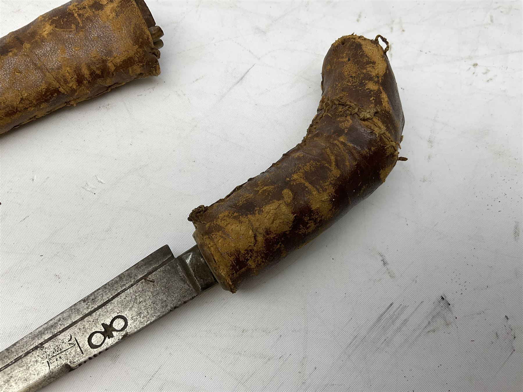 Near pair of African Moroccan Berber tribal Shula daggers each with engraved 39cm curving fullered steel blade, carved and inlaid horn grip and leather covered scabbard L57cm overall; kindjal style dagger with brass covered and jewelled grip and scabbard; another Eastern dagger with leather covered grip and scabbard; and a large Eastern knife with animal hide scabbard (5)