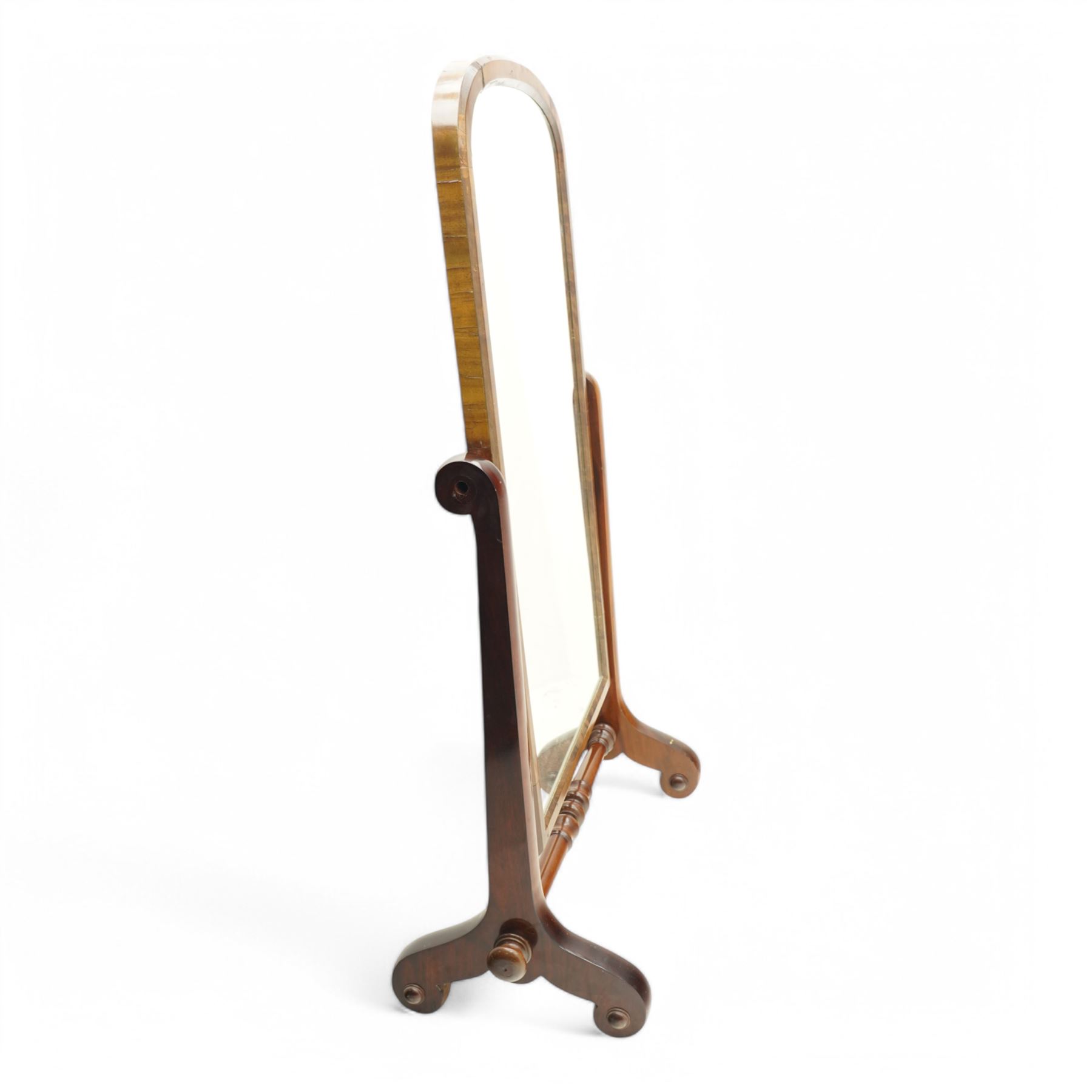 Early 19th century mahogany cheval dressing mirror, plain mirror plate within chamfered frame with arched top, on rolled horns and out-splayed rolled feet, united by turned stretcher 