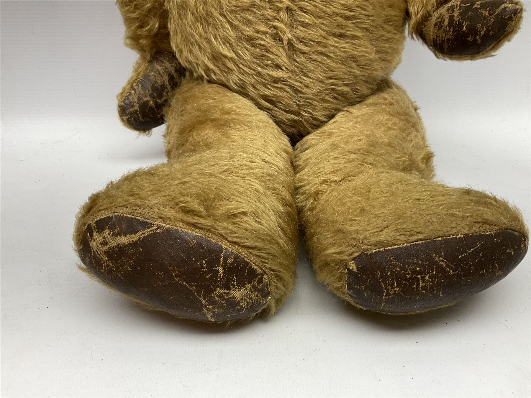 Mid-20th century plush covered teddy bear the revolving head with applied eyes, vertically stitched nose and jointed limbs with rexine pads H58cm; together with a leather backpack (2)