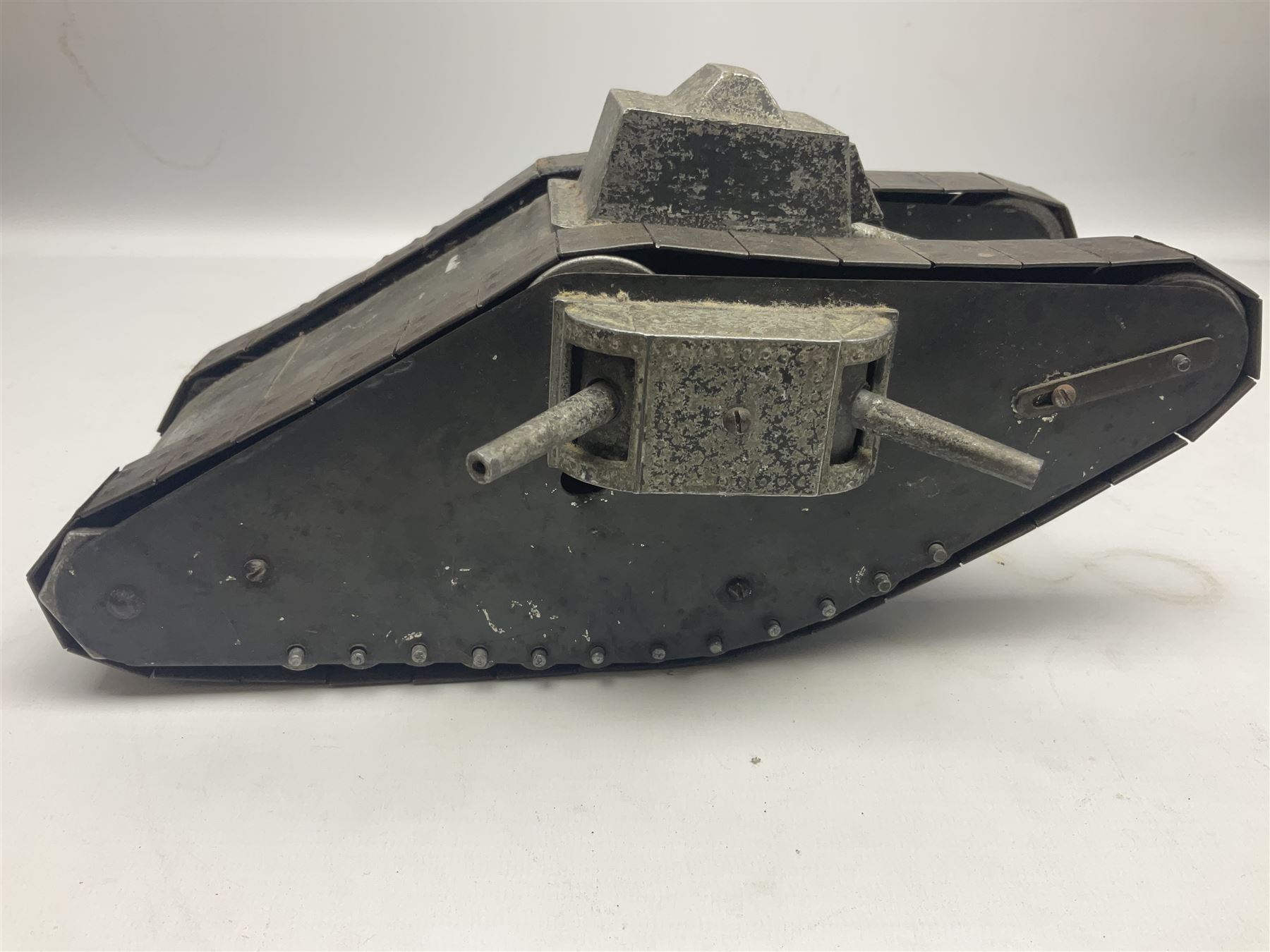 Large clockwork model of a WW1 Tank made of tin-plate and aluminium, with moving side cannons, the clockwork chain driven movement driving the articulated tin tracks; L28.5cms  W16.5cms and H13.5cms