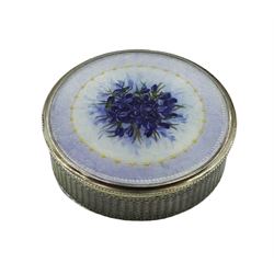 Swiss silver and enamel box and cover, of circular form, the body with engine turned decoration, the removable enamelled cover decorated with a spray of purple flowers within a lilac border, the interior stamped FBE Geneve 935, D5cm 