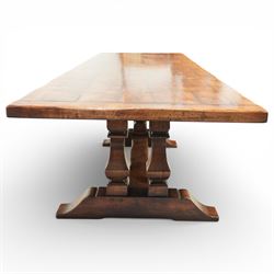 Country House 12' oak and fruitwood refectory dining table, the substantial rectangular plank top with cleated ends and chamfered edge, raised on twin trestle end square tapering and turned baluster supports with sledge feet and chamfered united by a long stretcher rail