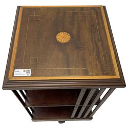 Edwardian inlaid mahogany revolving bookcase, square top with central fan inlay and satinwood banding with step moulded edge, upright splats and central square column supporting two tiers each with four divisions, on cruciform base with brass and ceramic castors