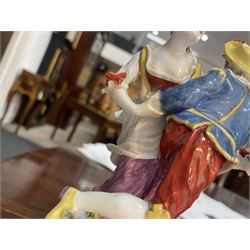 Mid 18th century Meissen figure group, The Tyrolean Dancers, circa 1740, modelled as two swirling figures with their arms linked, he in yellow hat with red rosette, blue jacket, red breeches with red rosette, and yellow shoes with green rosette, she in white blouse with red ribbons, yellow and red bodice, white apron over puce skirt and yellow shoes with green rosettes, her hair fashioned into two plaits secured by red ribbon, upon a shaped mound base, within a scrolling gilt metal mount, with blue crossed swords mark to base, overall H19cm
