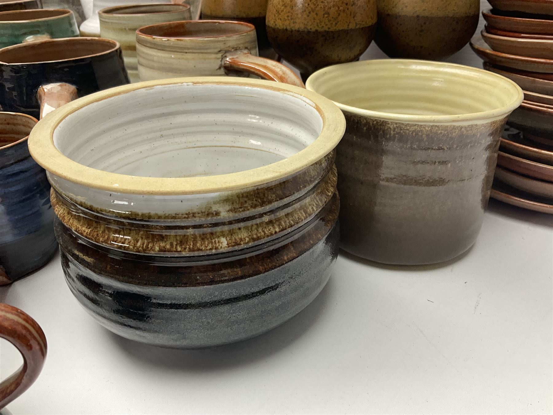 Wold studio pottery tankards, in various colours and relief decoration together with other studio items including vases, jugs and pots 