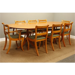  Large yew wood dining table, oval top on twin pedestal base with splayed reeded supports (245cm x 123cm, H73cm), and set eight (6+2) dining chairs with saber legs and drop in seats  
