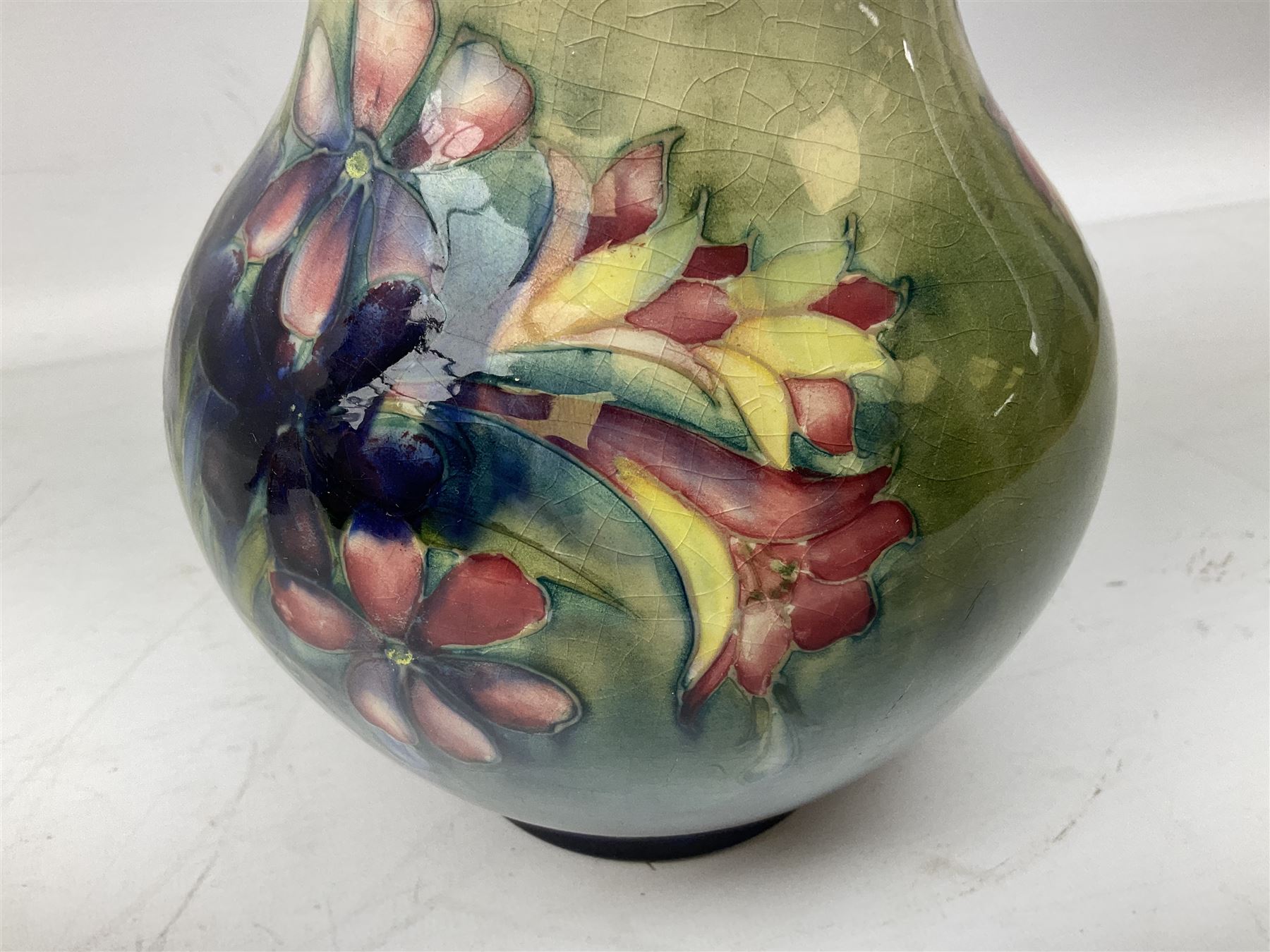 Moorcroft vase of baluster form decorated in the Spring Flowers pattern upon a merging green and blue ground, with impressed and painted marks beneath, H22.5cm