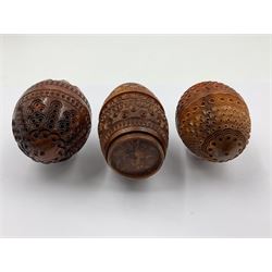 Three 19th century coquilla nut pomanders or flea catchers, two of egg shaped form and the third of barrel from with carved and pierced decoration and screw threaded join, largest H8cm