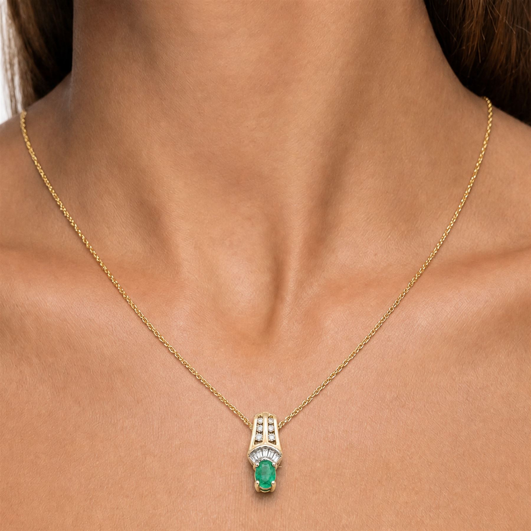 14ct white and yellow gold emerald and diamond pendant necklace, five tapered baguette cut diamonds and six round cut diamonds, suspending a single oval cut emerald of approx 0.45 carat, on a Singapore link chain necklace