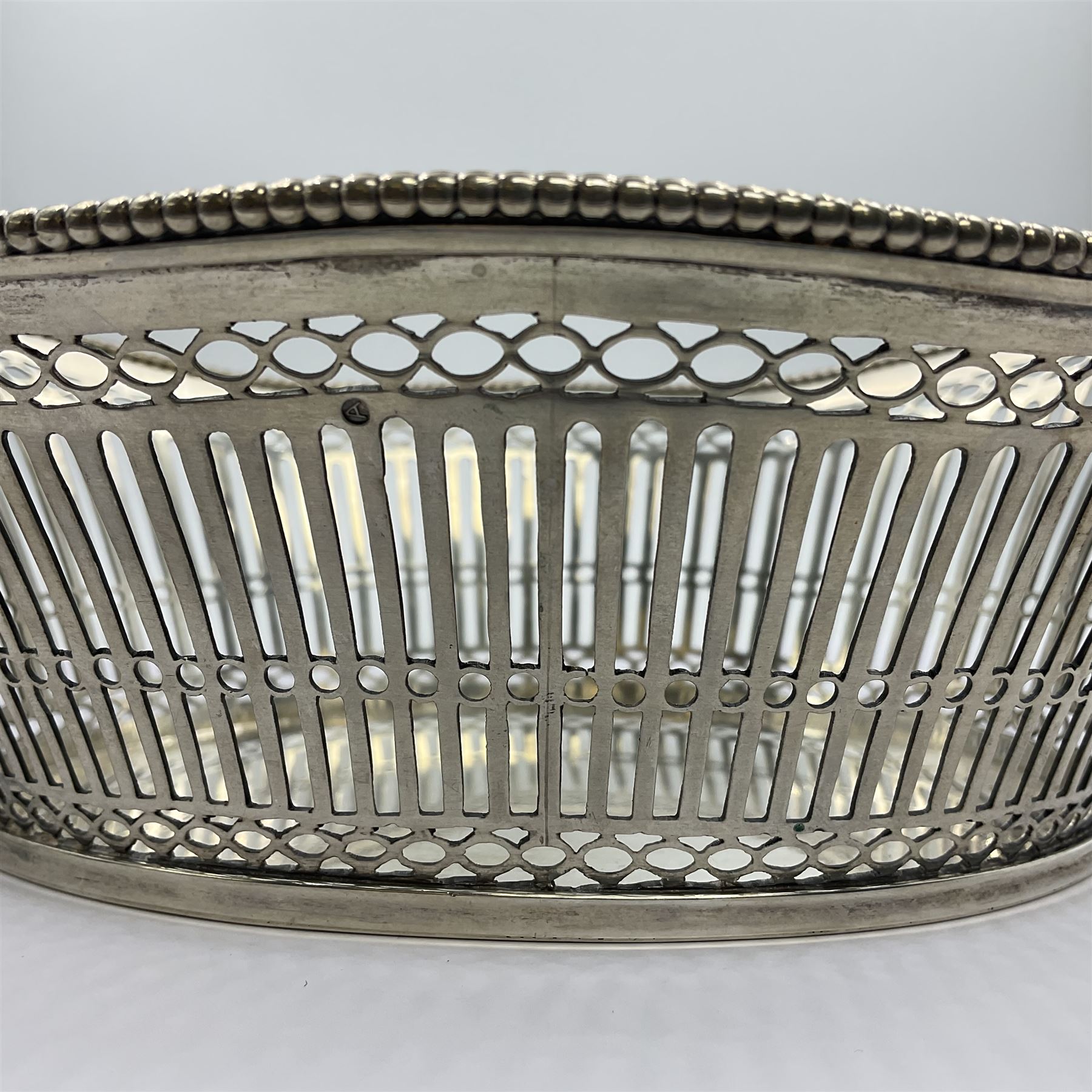 Early 20th century Dutch silver basket, of oval form with pierced sides, beaded rim, and twin handles, marked with Lion Passant for 2nd standard purity and date letter for 1910, other marks worn and indistinct, including handles H8.5cm L25.5cm