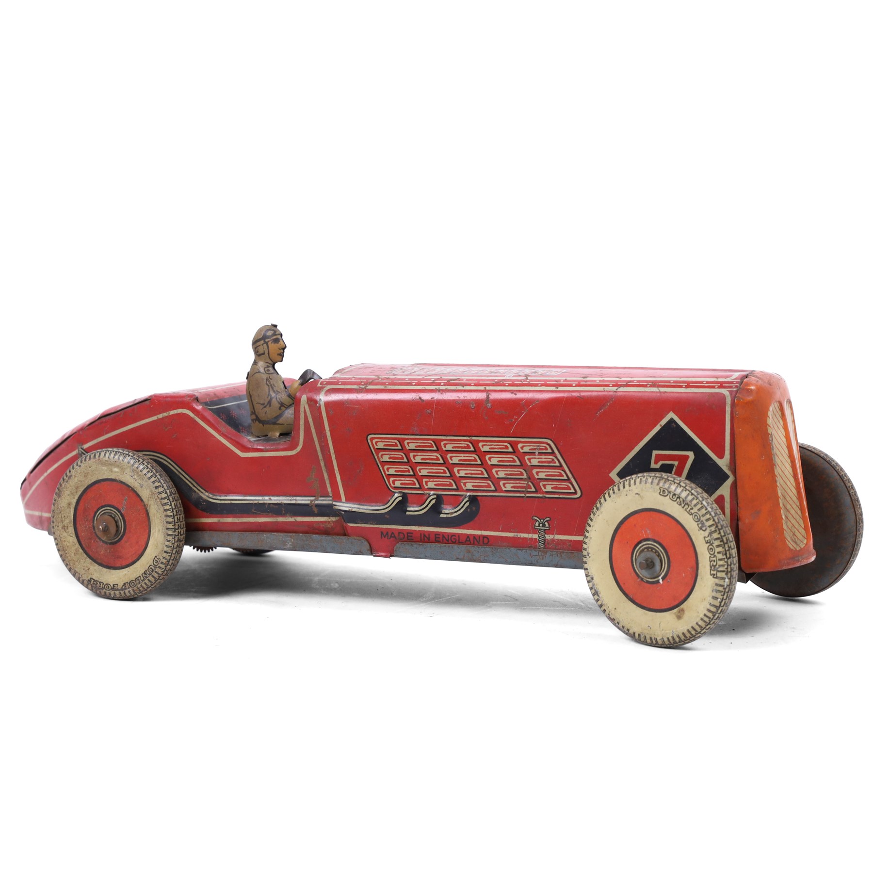 Mettoy tinplate clockwork racing car, the boat tailed red body with lithographed details, racing no. 7, with Dunlop Fort tyres, driver and key, H8cm, L32cm