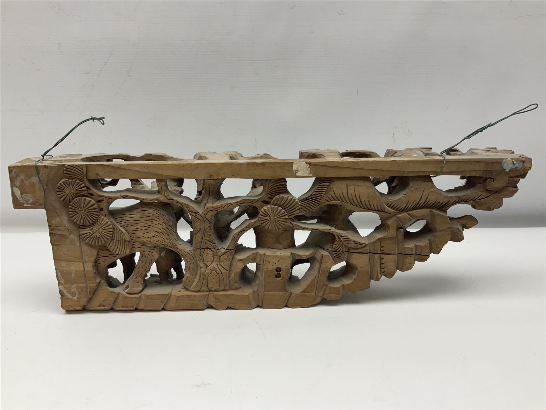 Two carved oriental wall hangings, the first example gilded depicting a temple and garden scene, the second figures in a garden, L49cm