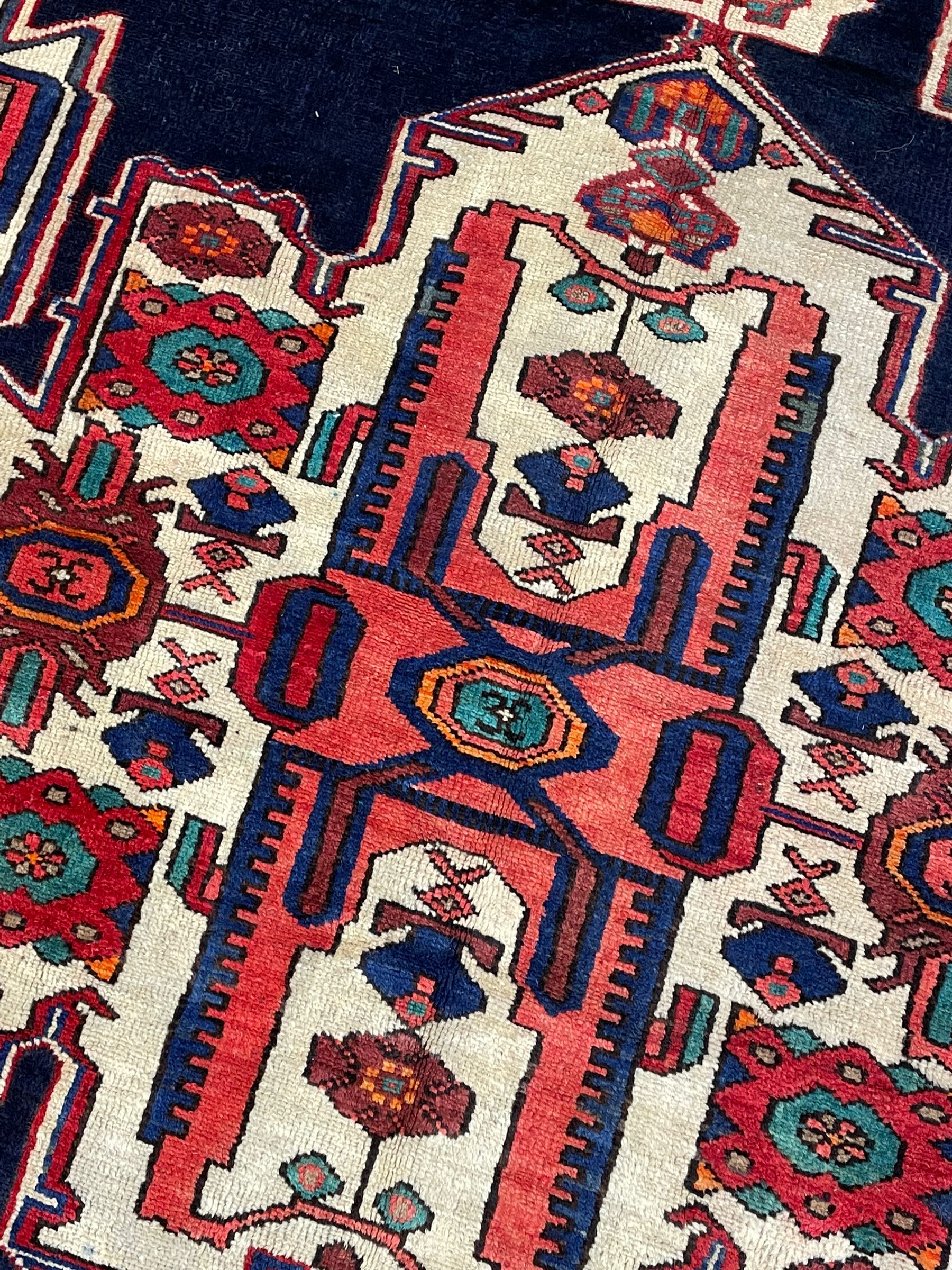 North West Persian Heriz rug, blue and ivory ground, decorated with stylised plant motifs, the border decorated with repeating geometric design 