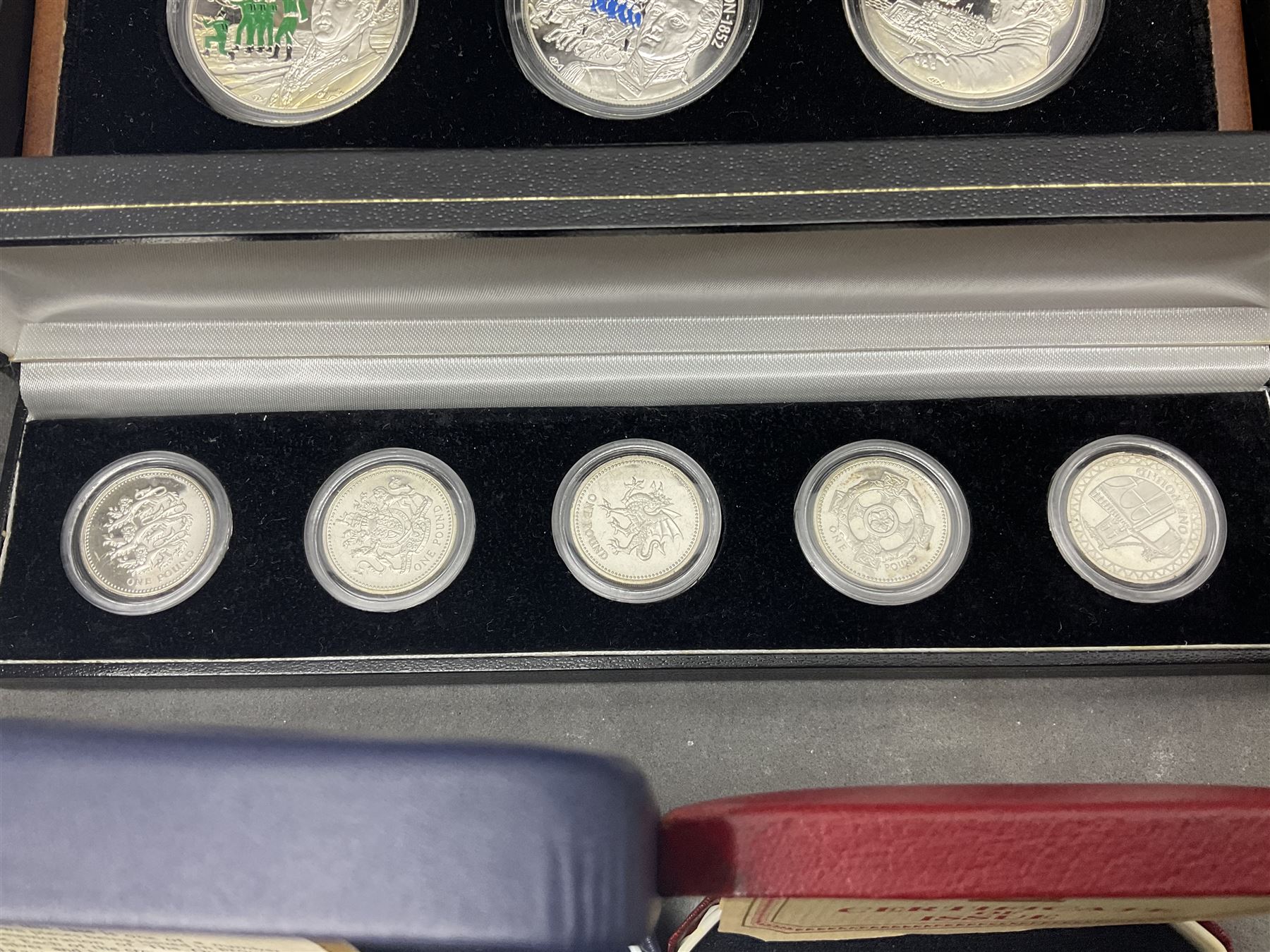 The Royal Mint United Kingdom 1977 silver proof two coin set, Queen Elizabeth II 2002 silver proof three coin set, comprising Bailiwick of Jersey, Bailiwick of Guernsey, and Alderney five pound coins, 'First Coinage of the British Virgin Islands' proof set, 1997 1/10 ounce fine silver Britannia, two King George V 1935 'Rocking Horse' crowns, various Isle of Man commemorative crowns, etc., house in a hard shell carry case